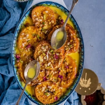 Shahi Tukda served on a plate with 2 spoons on it.