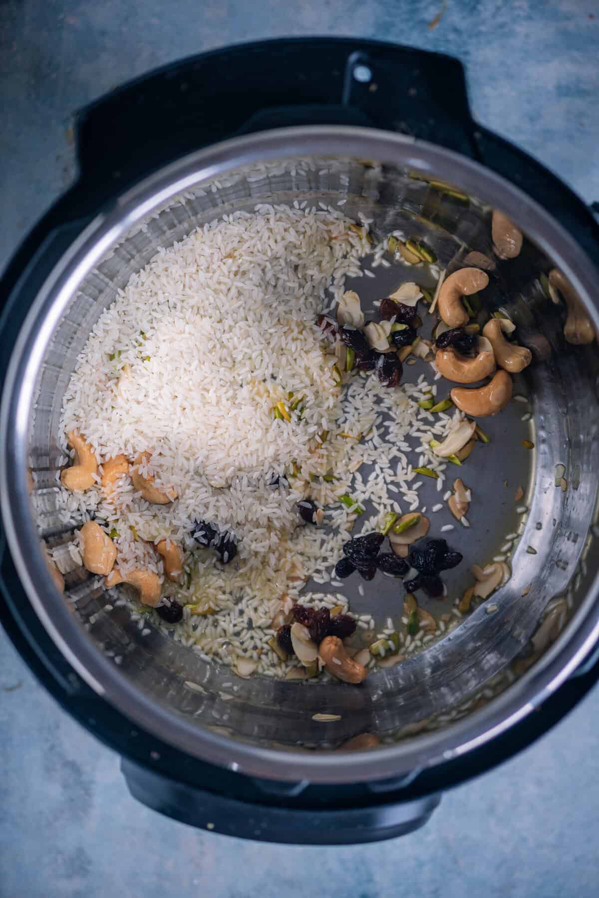 Raw basmati rice being toasted in an Instant Pot for rice kheer.