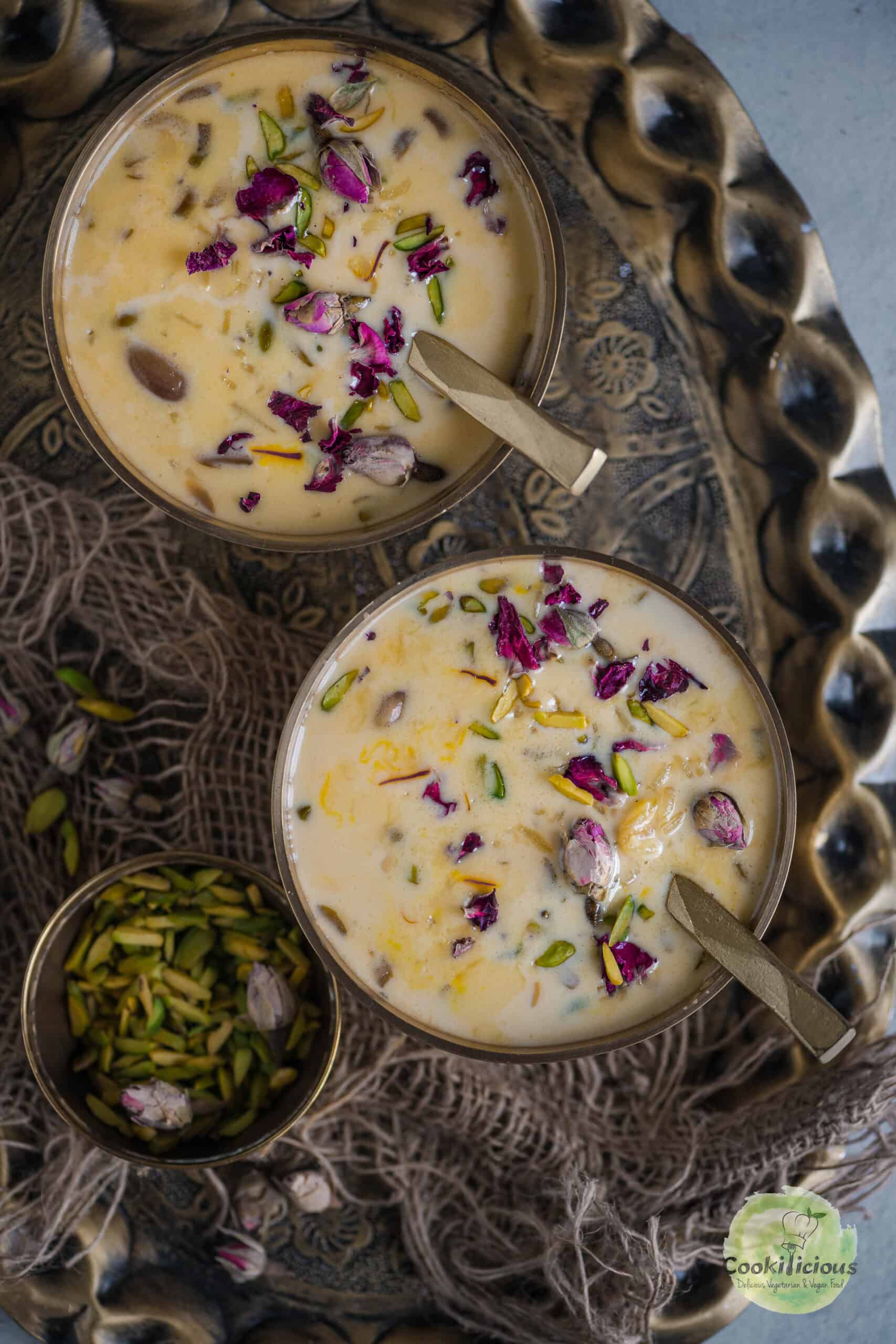 Rice Kheer served in 2 bowls with spoons in them.