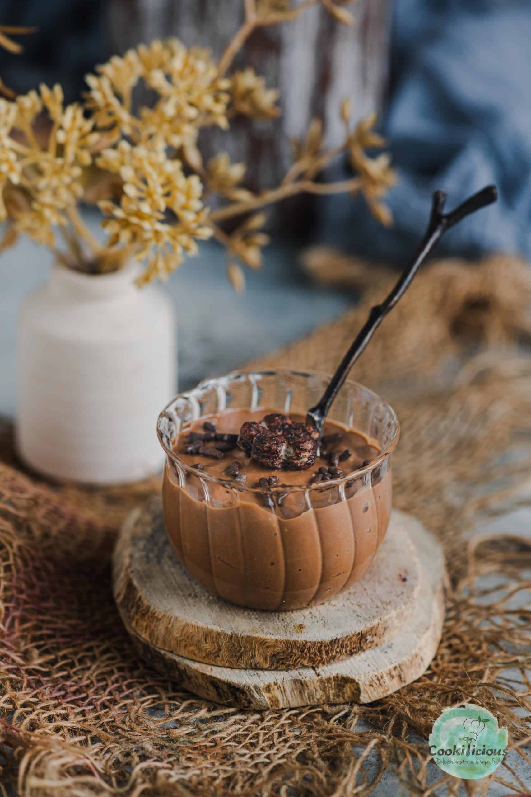 Indulgent vegan chocolate ricotta mousse served in a mini jar with a spoon in it.