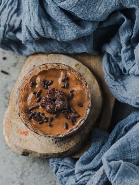 top angle view of healthy dairy-free chocolate mousse in a small jar and text at the top.