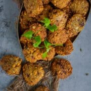 Golden-brown crispy dal vadas stacked on a plate, garnished with fresh cilantro.