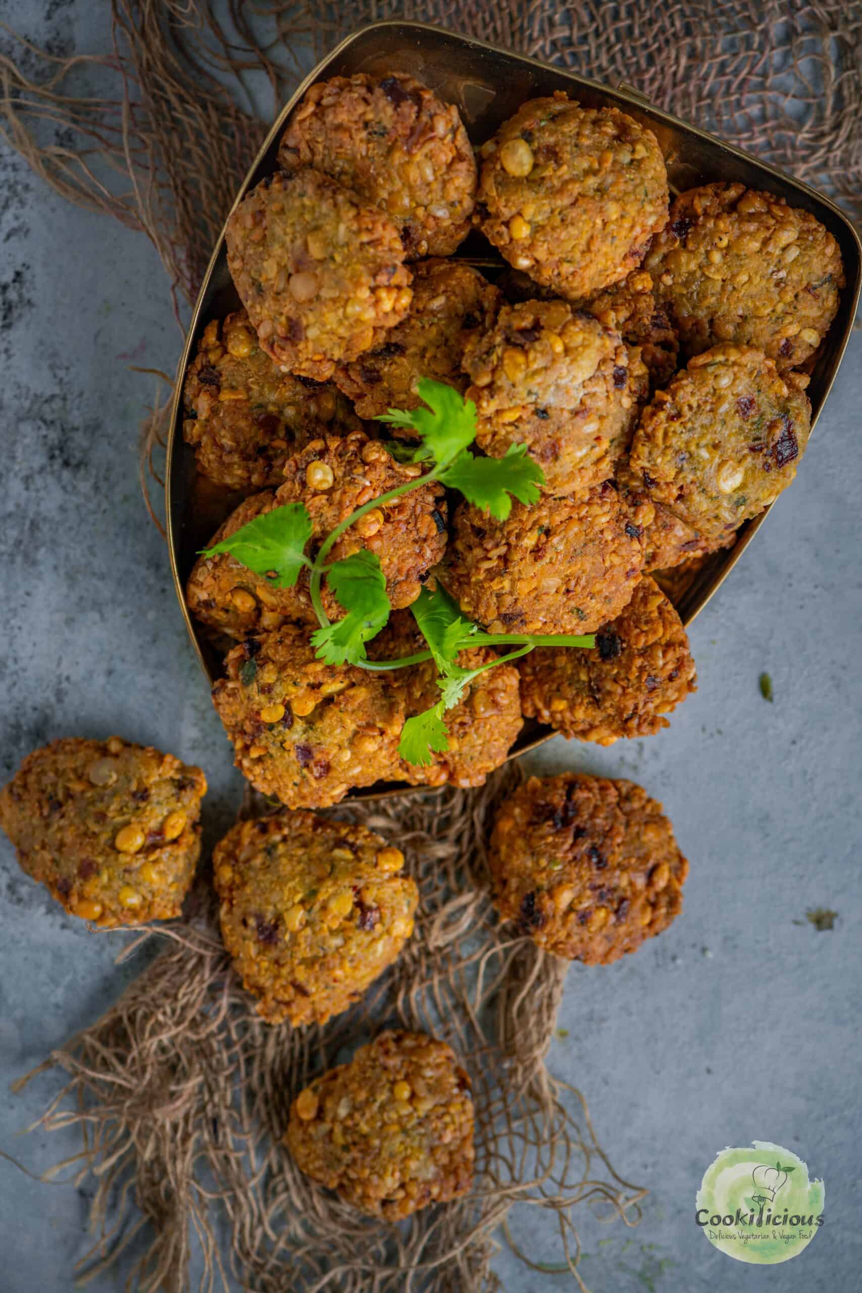 Golden-brown crispy dal vadas stacked on a plate, garnished with fresh cilantro.