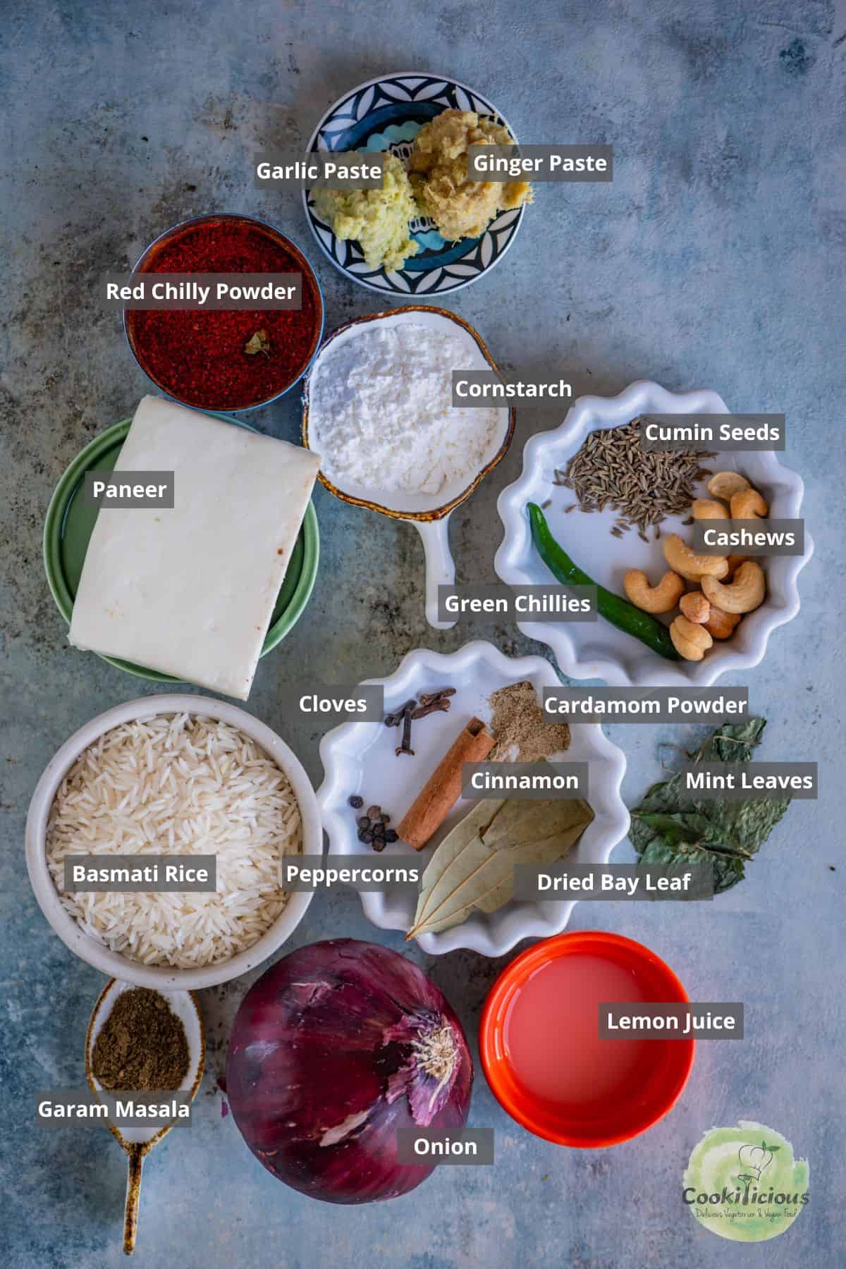 all the ingredients needed to make paneer pulao placed on a table with labels on them.