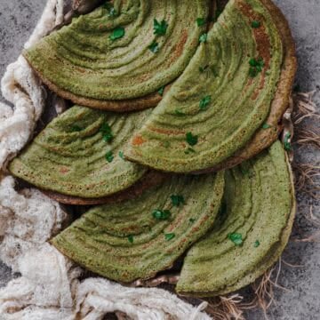 A stack of freshly made Pesarattu, showcasing their crispy texture.