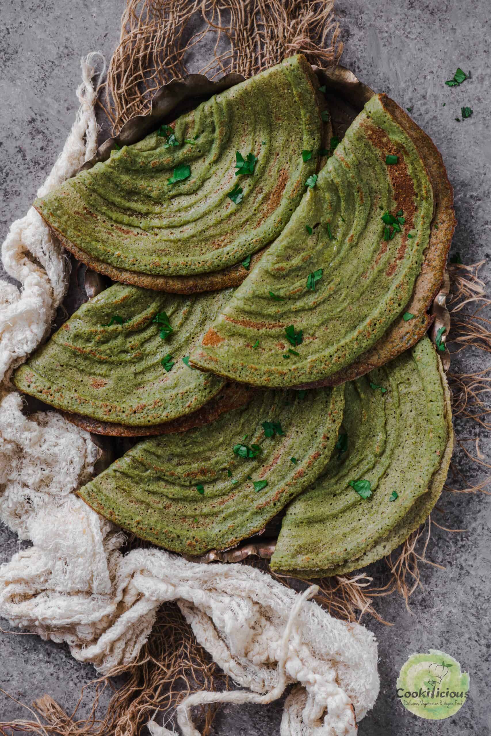 A stack of freshly made Pesarattu, showcasing their crispy texture.