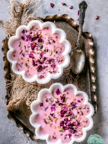 2 bowls of Basundi dessert served in a tray with a spoon on the side.