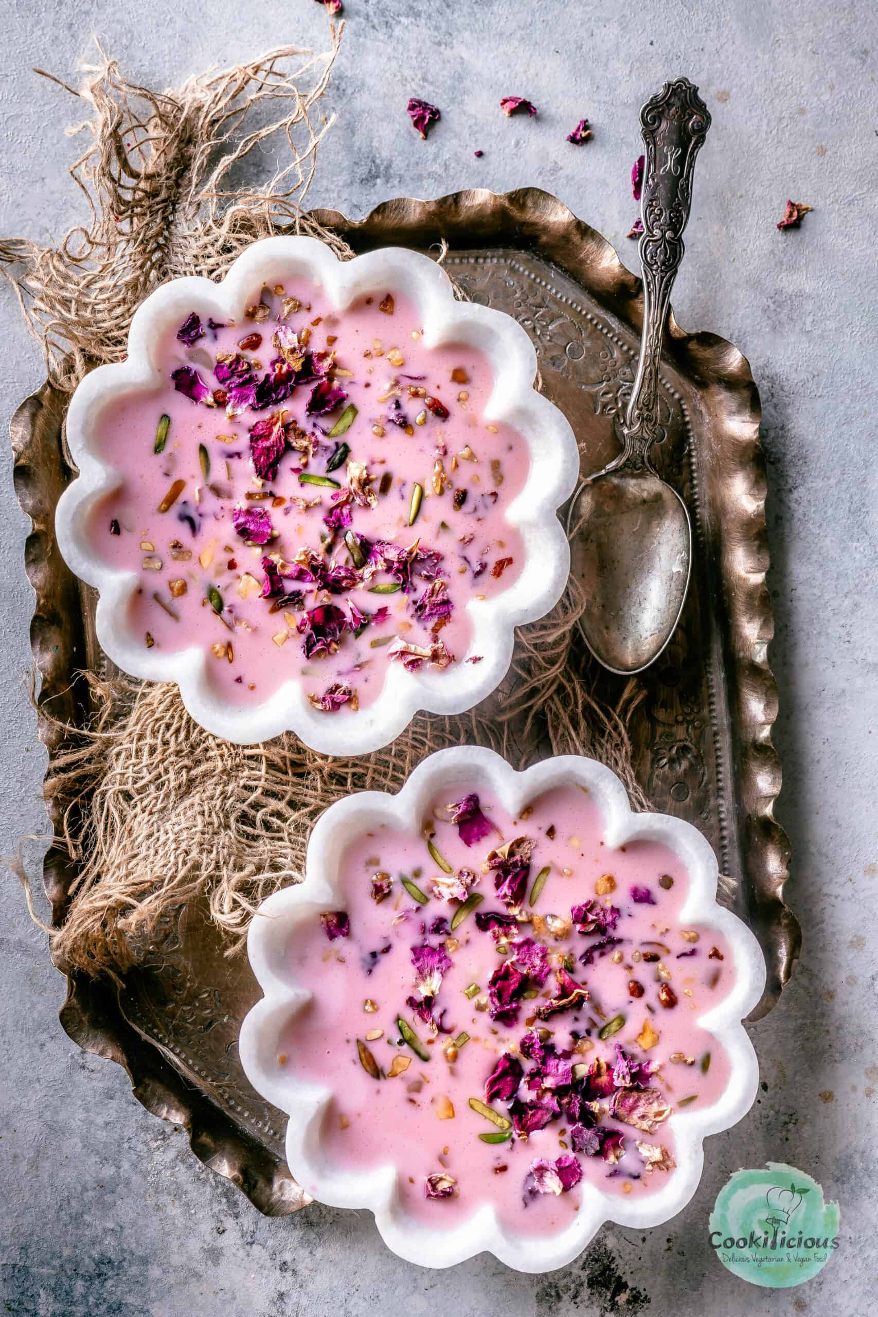 2 bowls of Basundi dessert served in a tray with a spoon on the side.