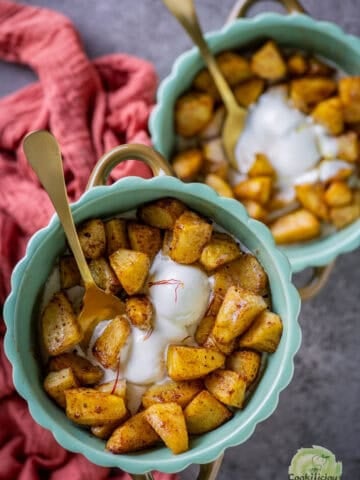 Air fryer apples served with ice cream in 2 bowls.