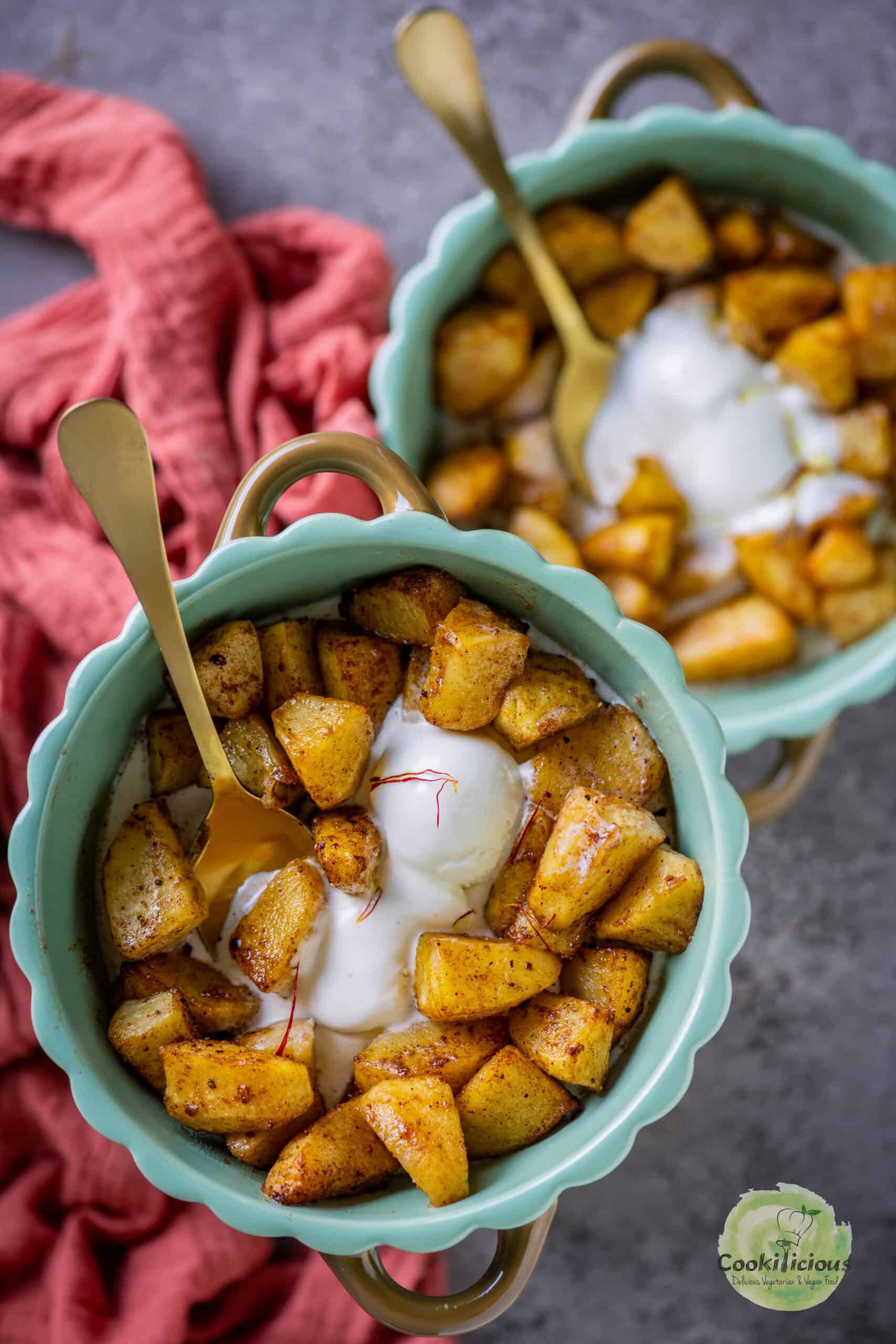 Air fryer apples served with ice cream in 2 bowls.