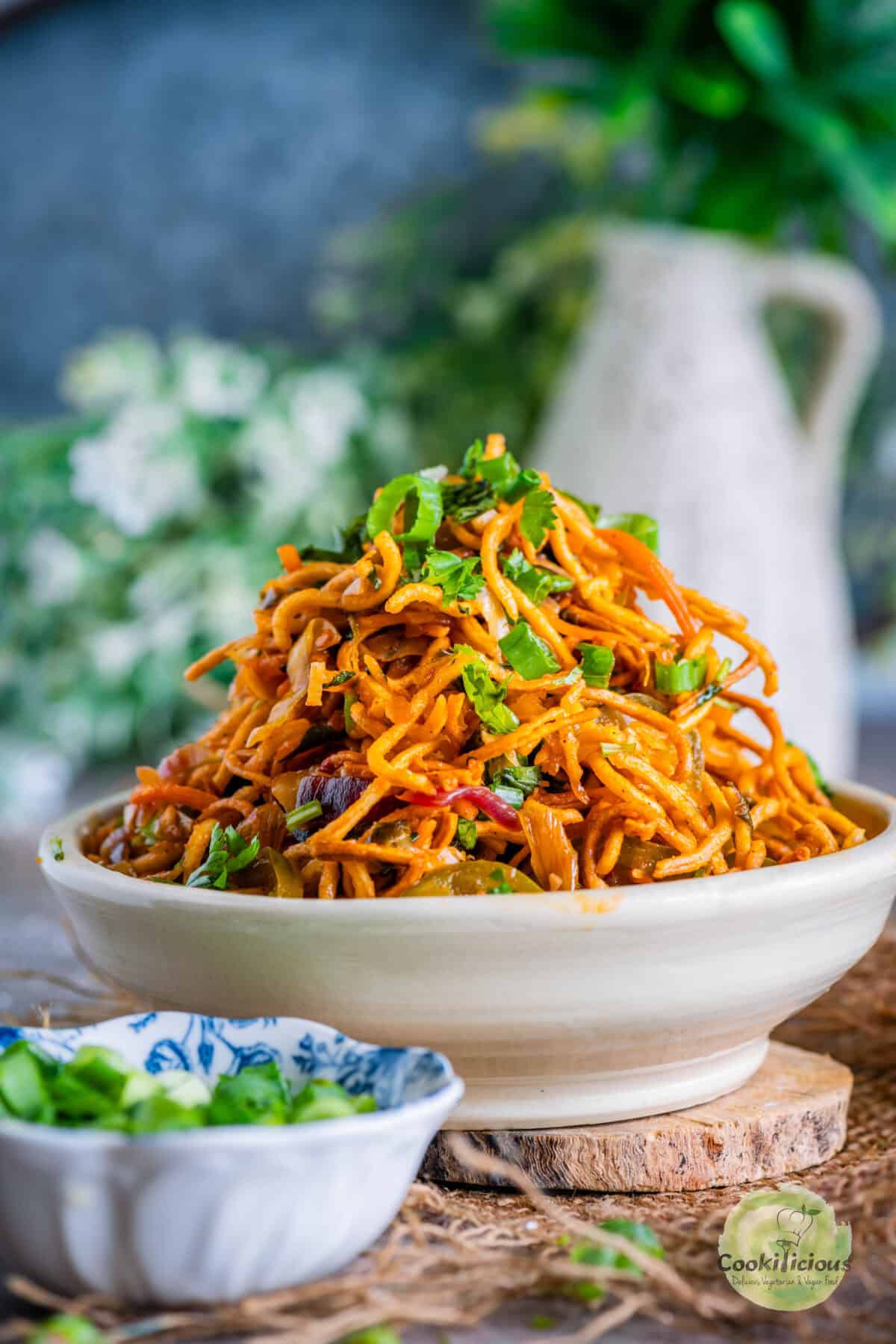 Crispy Chinese Bhel garnished with scallions served in a small plate.