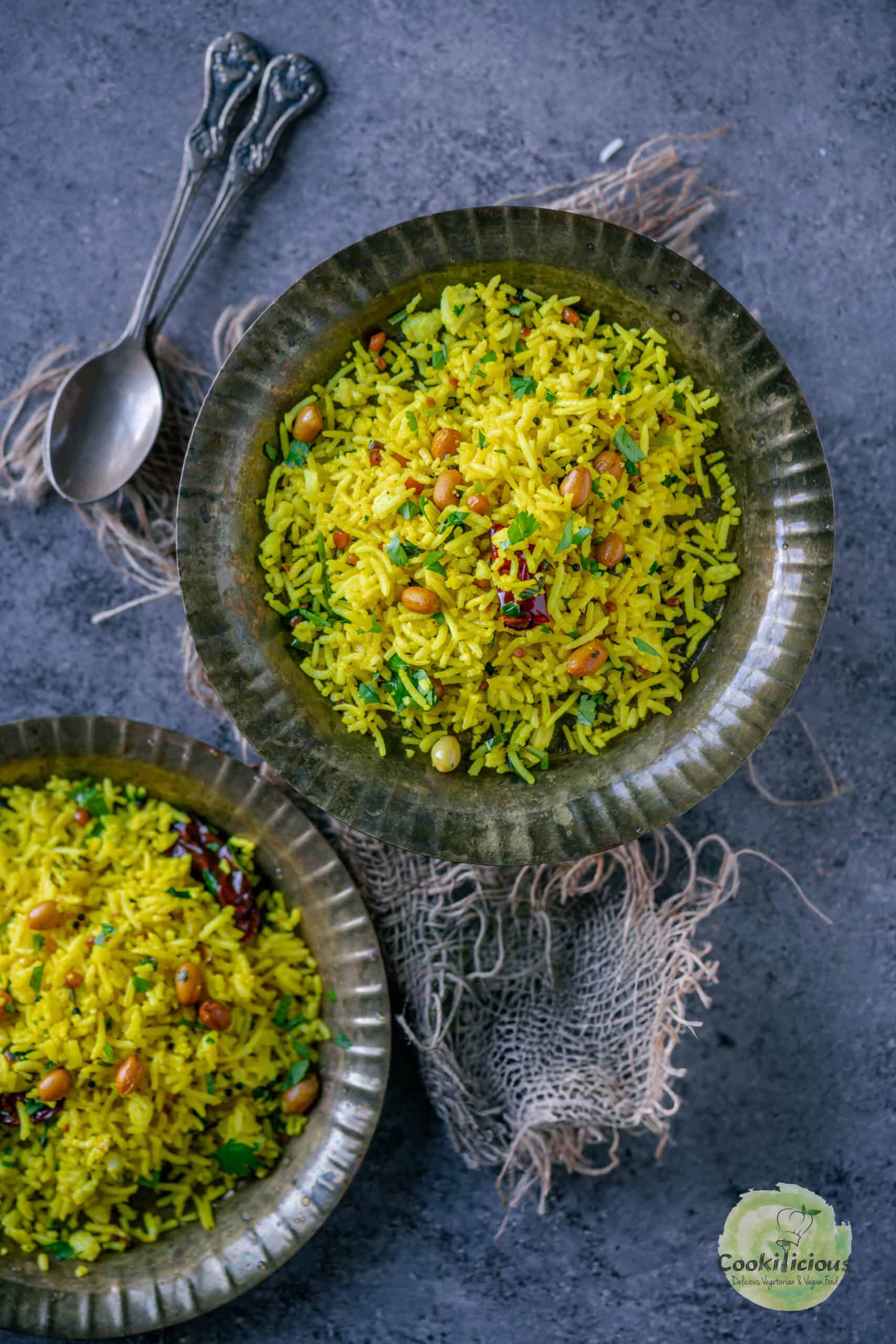 Yellow lemon rice with peanuts served in two plates.
