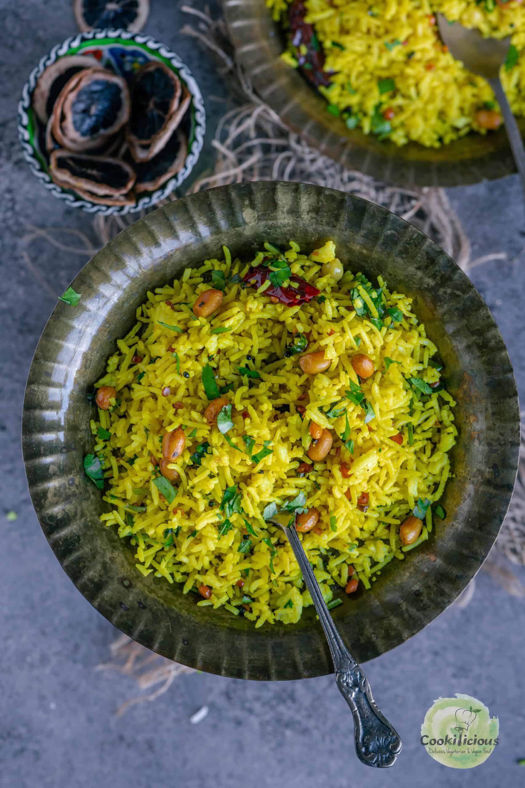 South Indian Lemon Rice served in a brass plate with a spoon in it.