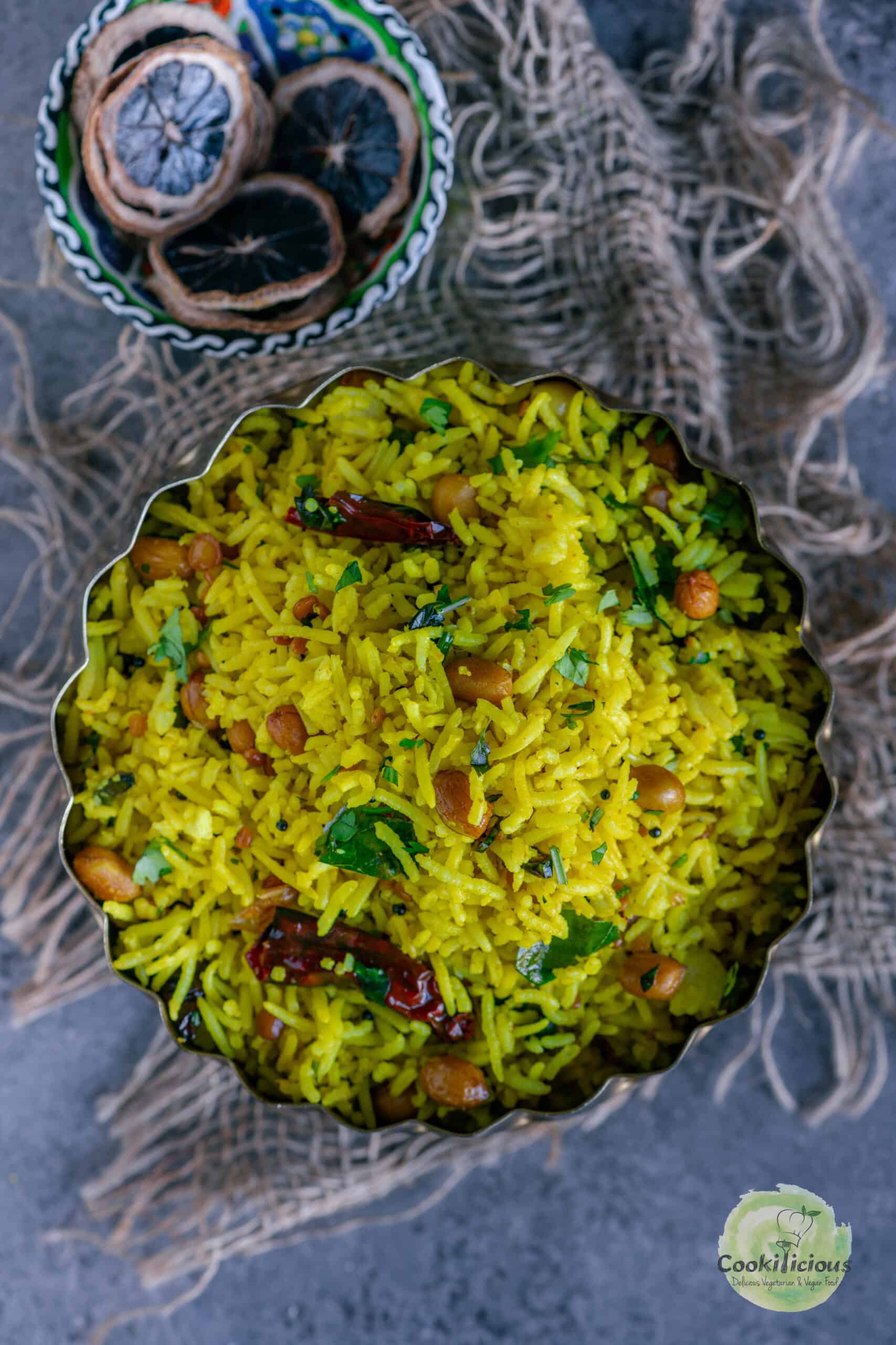 Authentic Indian Lemon Rice with peanuts, and curry leaves served in a plate.