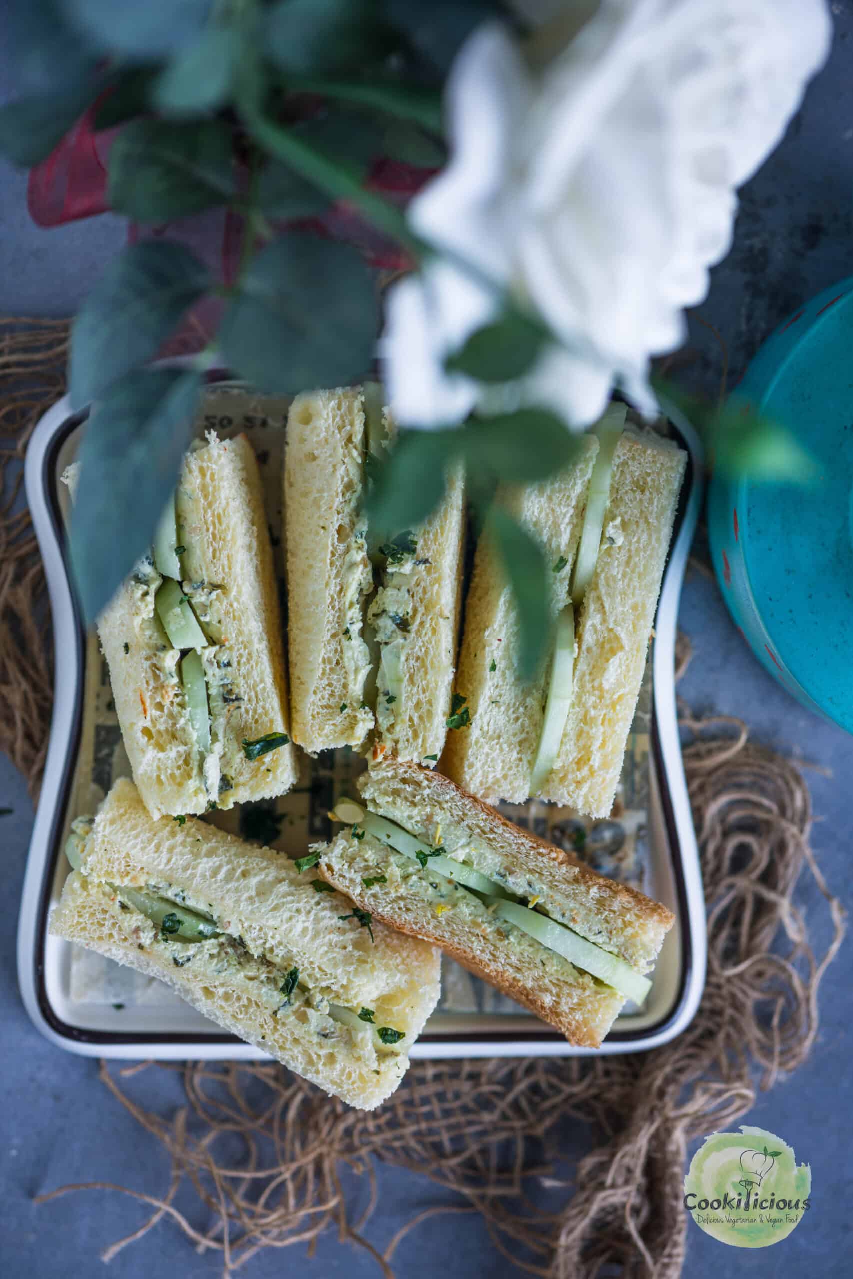Close-up of cucumber and cream cheese sandwich with herbed spread.