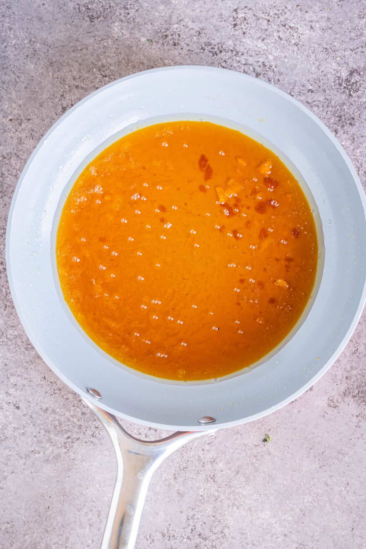 Jaggery melting and starting to boil in a pan.