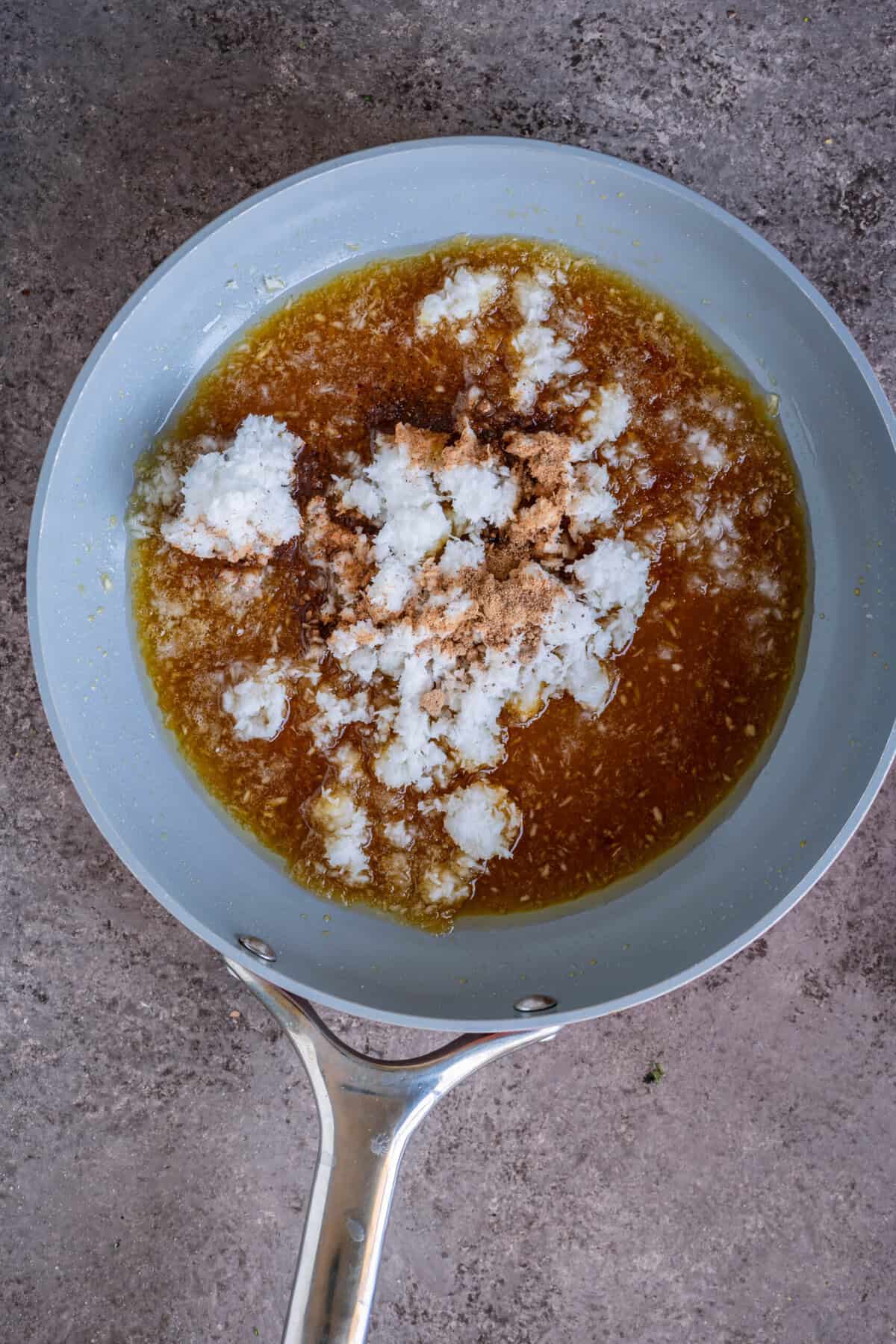 Grated coconut and cardamom powder added to the melted jaggery.