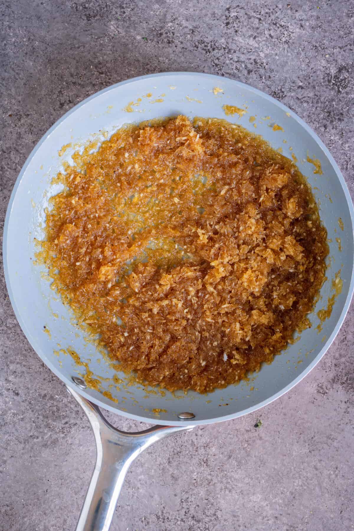 Coconut and jaggery mixture being stirred in a pan.