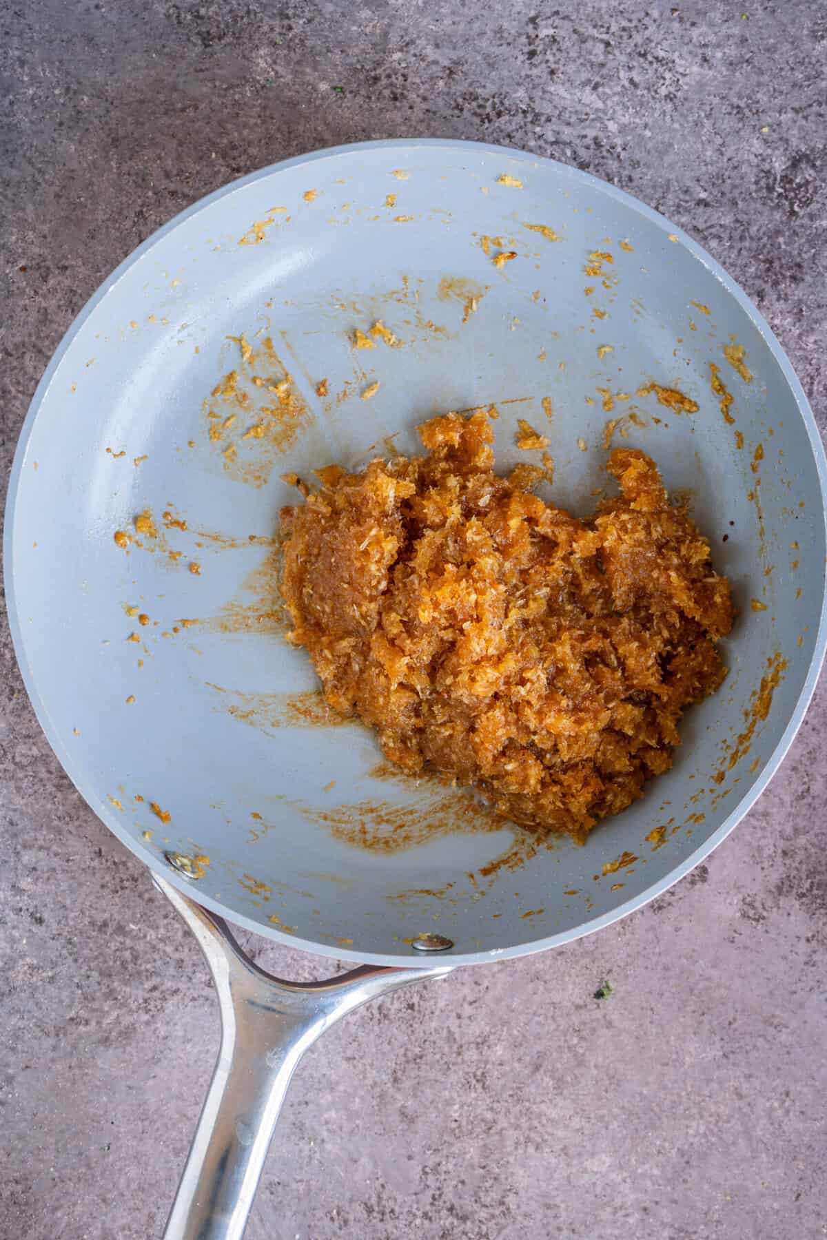 Thickened coconut jaggery stuffing pulling away from the sides of the pan.
