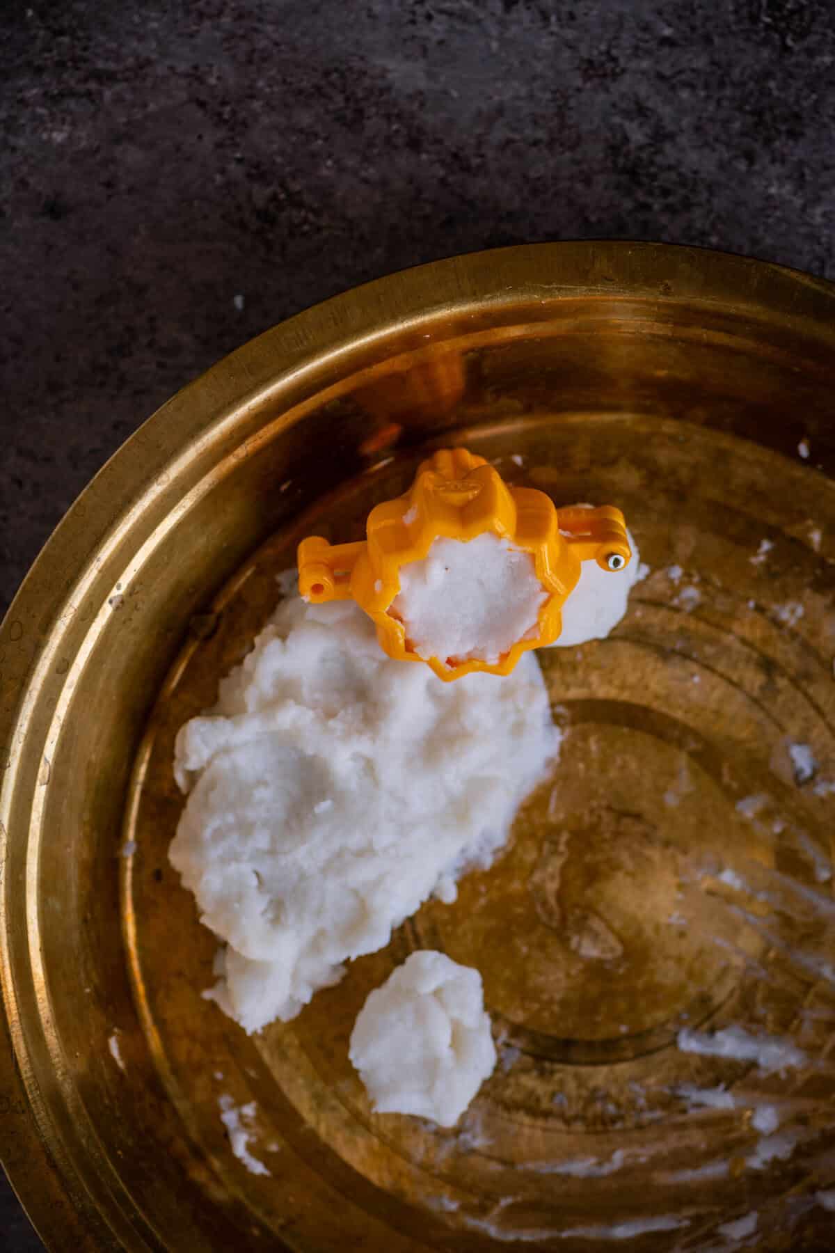 Rice flour dough pressed into a greased modak mold.