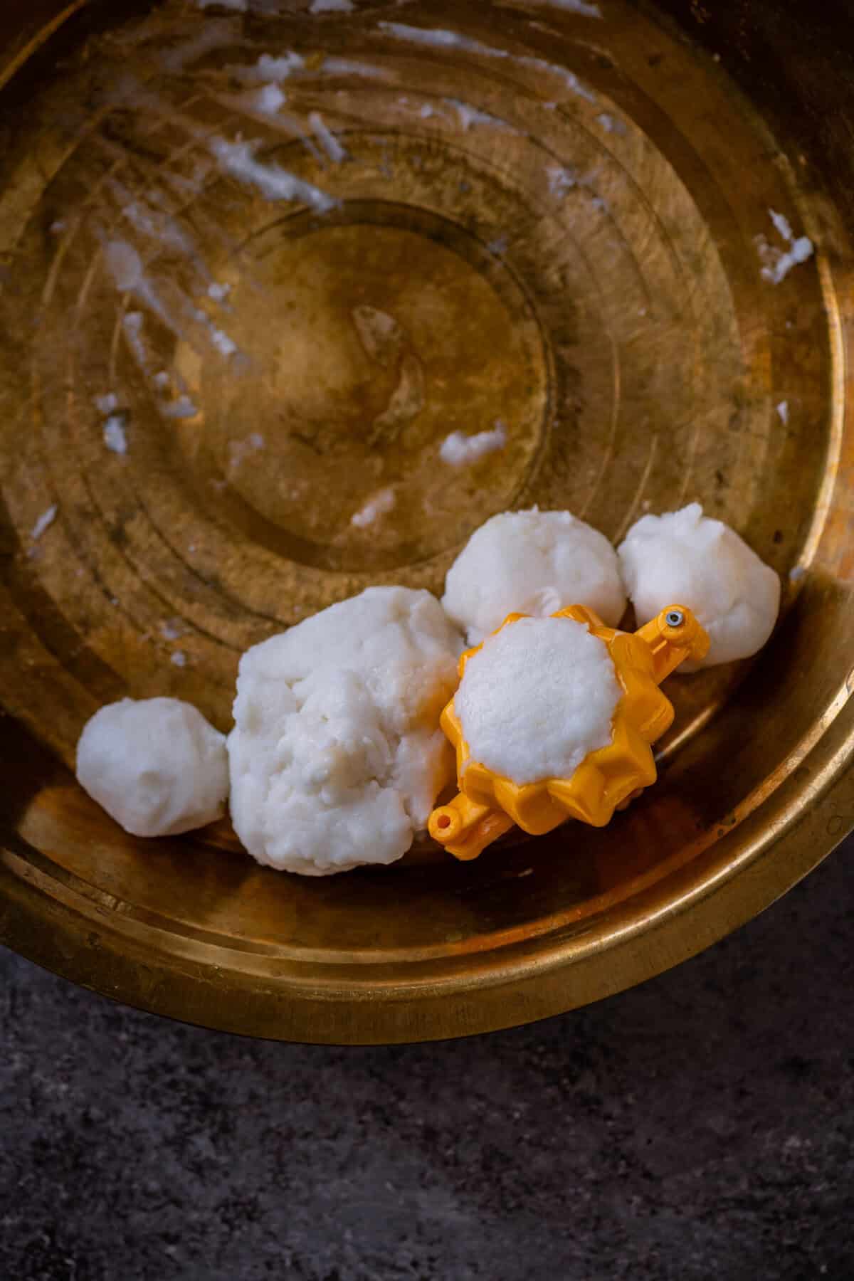 Dough sealed over the base of the modak inside the mold.