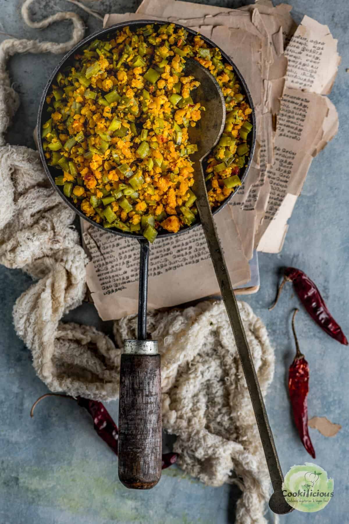 Kothavarangai Paruppu Usili served in a plan with a ladle in it.