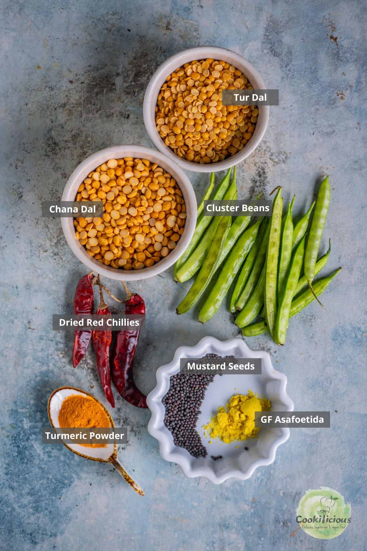 all the ingredients needed to make Kothavarangai Paruppu Usili placed on a table with labels on them.