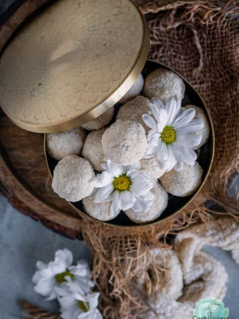 Delicious vegan and gluten-free Rava Laddu (Rava Ladoo) served in a brass dabba.