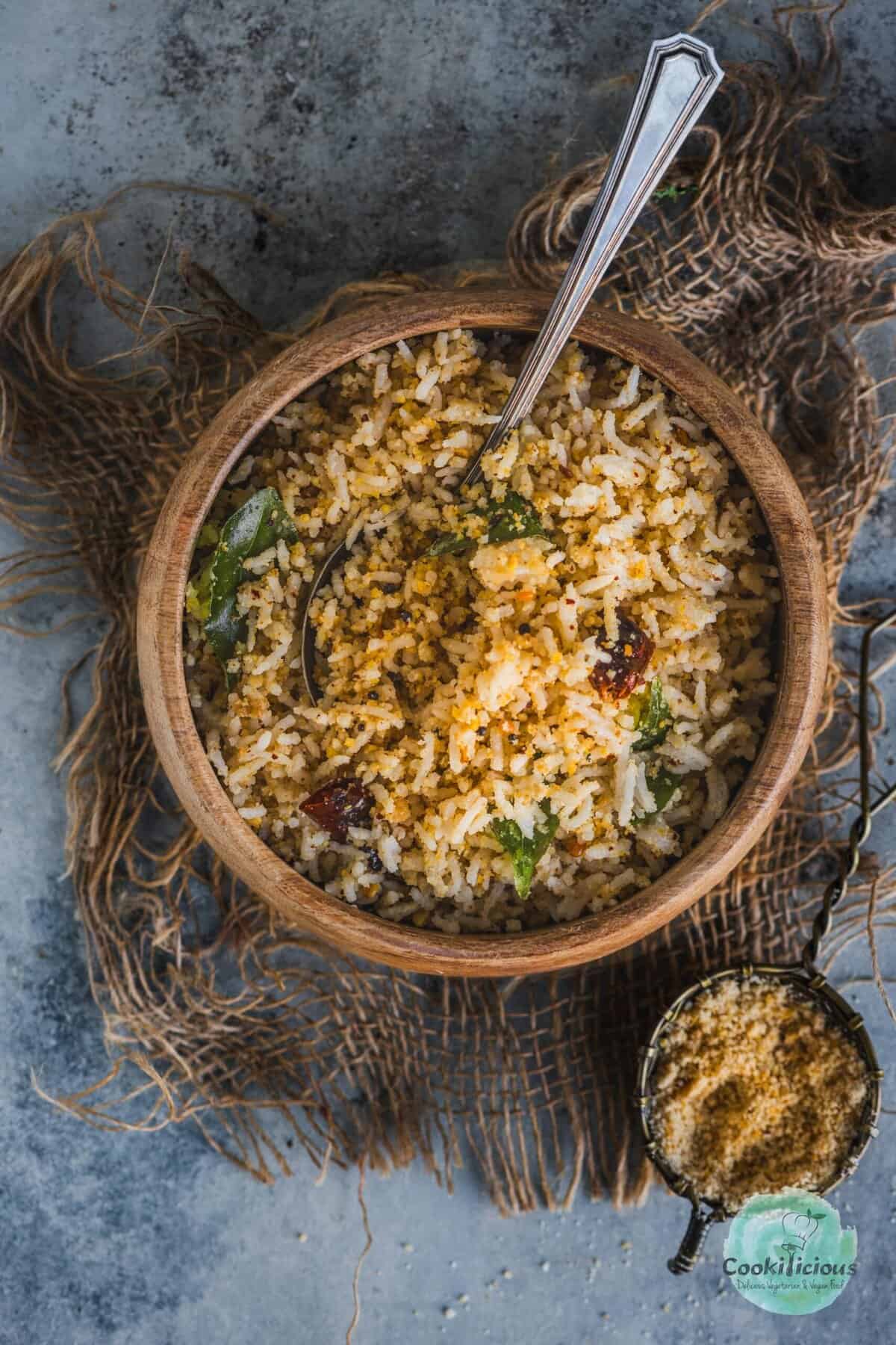 Serving Indian sesame rice in a traditional South Indian bowl with a spoon in it.