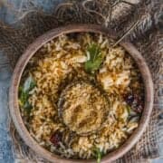 a bowl of sesame rice served with a small bowl filled with ellu podi in the middle.