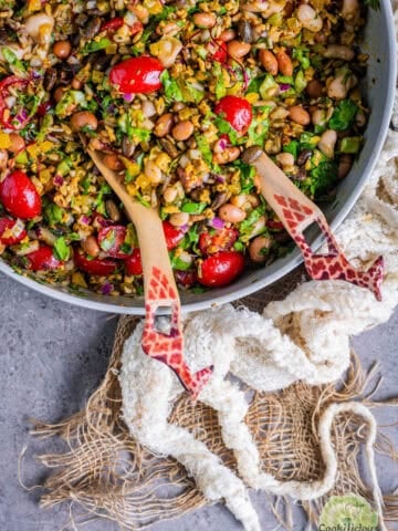 Close-up of colorful vegan Dense Bean Salad with black soybeans, pinto beans, cannellini beans, bell peppers, cherry tomatoes, and sunflower seeds.
