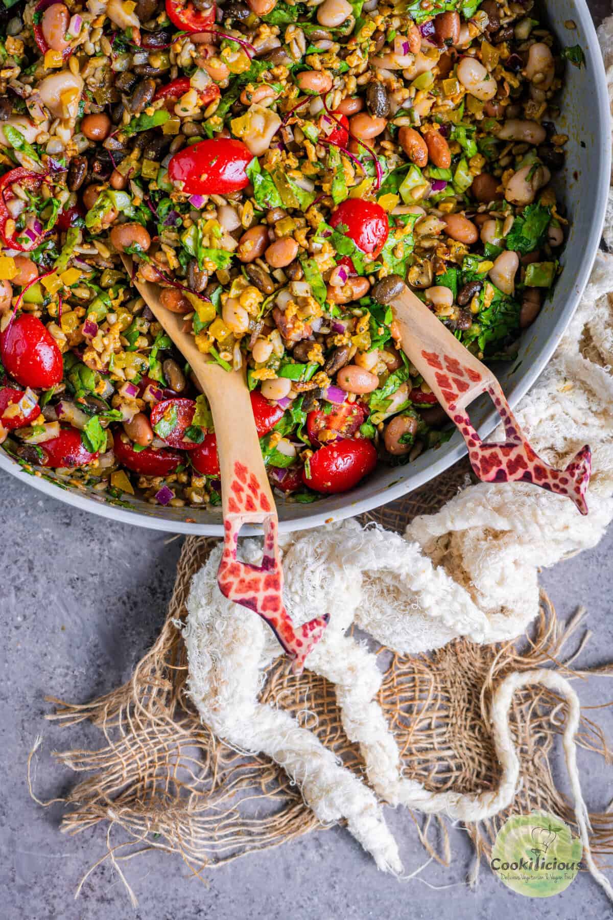 Close-up of colorful vegan Dense Bean Salad with black soybeans, pinto beans, cannellini beans, bell peppers, cherry tomatoes, and sunflower seeds.