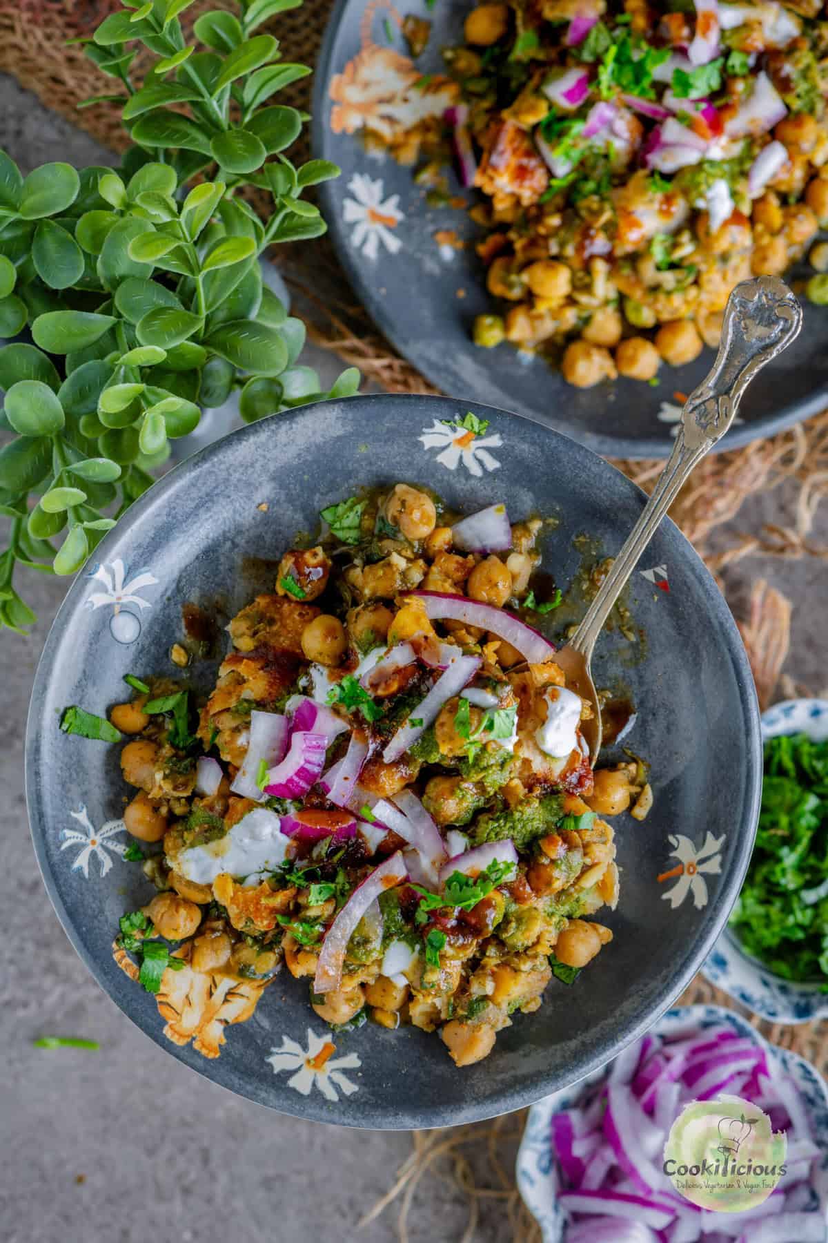Crispy golden samosas topped with spicy chole, tangy chutneys, yogurt, and crunchy sev – authentic Delhi street-style samosa chaat.