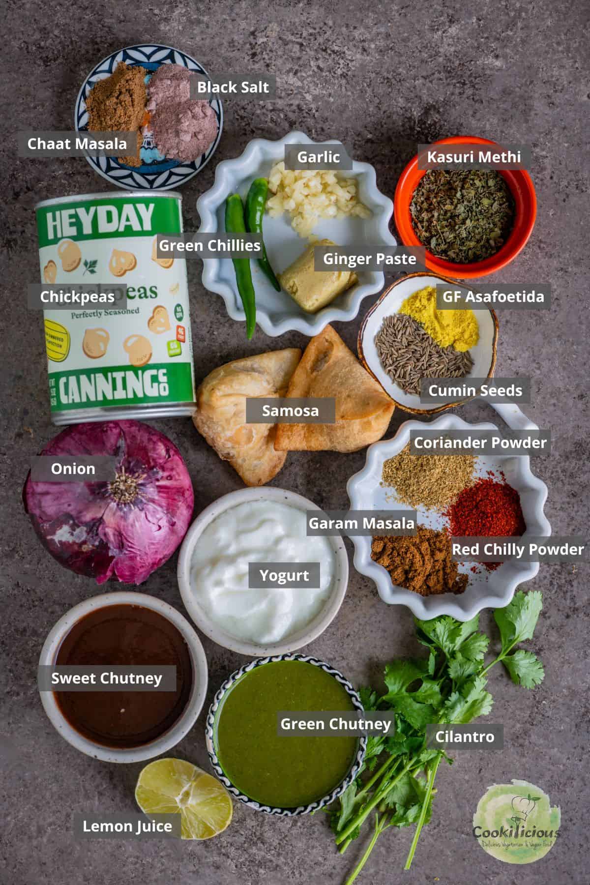All the ingredients needed to make Indian Samosa Chaat With chole placed on a table with labels on them.