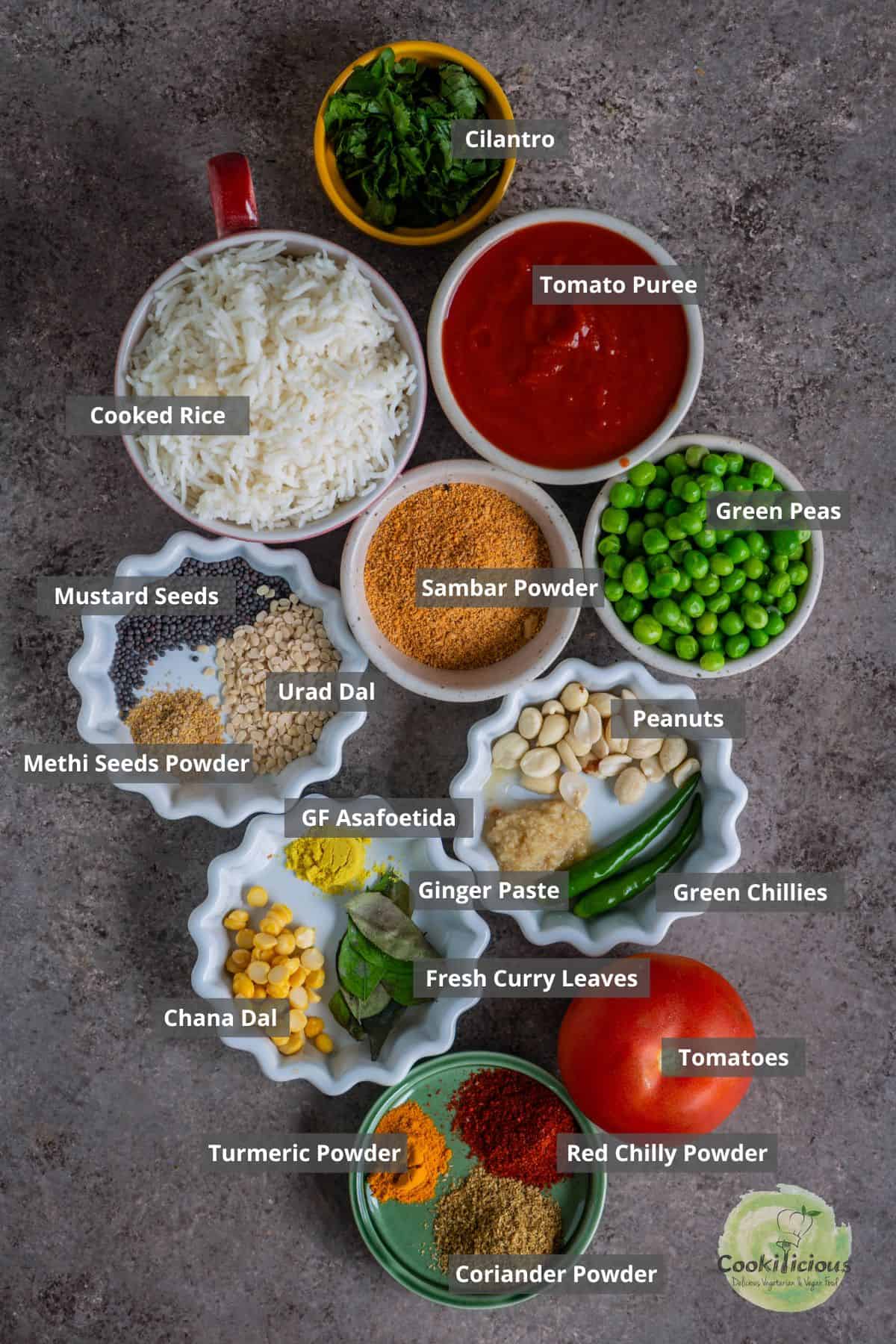 All the ingredients needed to make Indian Tomato Rice placed on a table with labels on them.