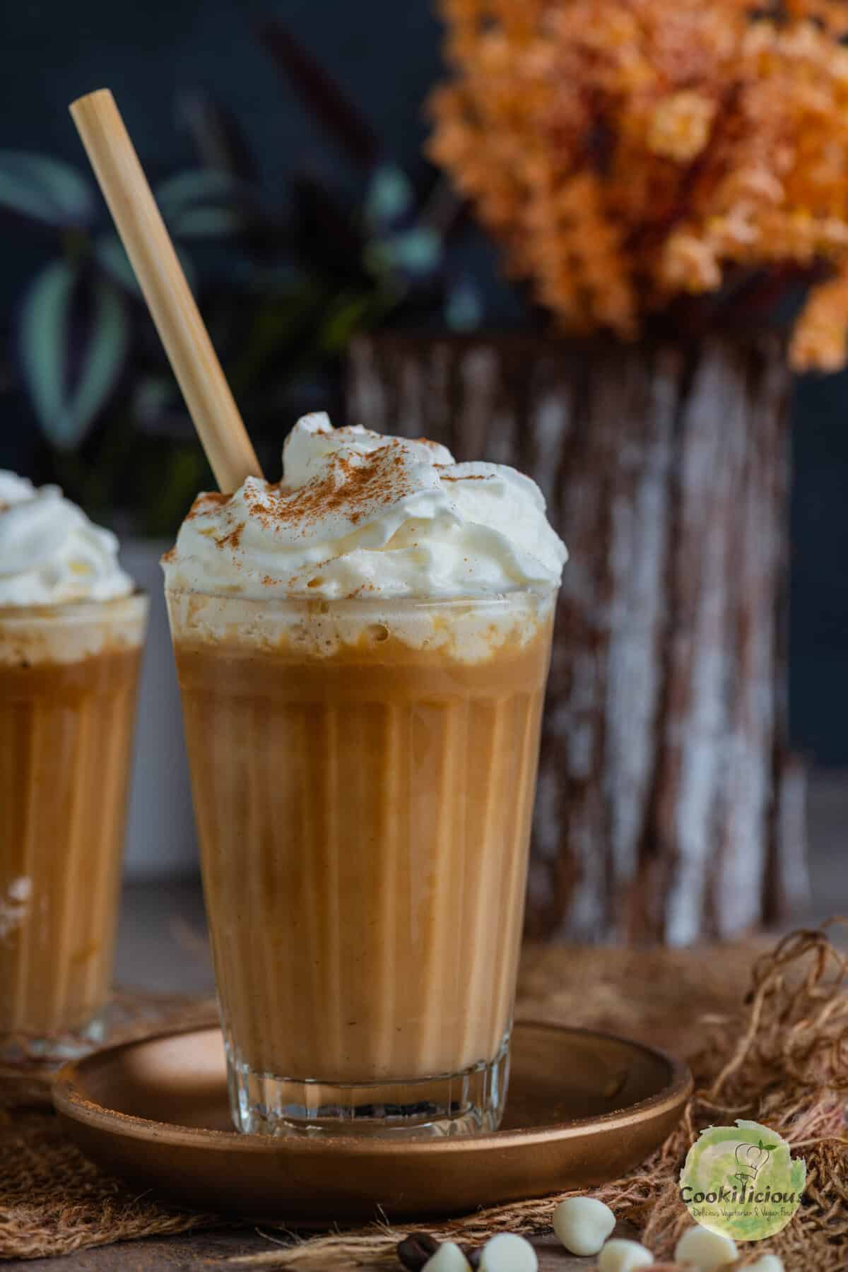 Dairy-free café mocha made with vegan white chocolate and topped with vegan whipped cream served with a wooden straw.