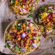 Cheesy Dabeli Pizza on mini pita bread with dabeli masala, pomegranate seeds, spiced peanuts, and crispy sev – easy Indian street food fusion snack.