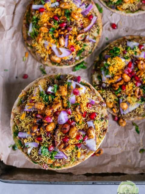 Cheesy Dabeli Pizza on mini pita bread with dabeli masala, pomegranate seeds, spiced peanuts, and crispy sev β easy Indian street food fusion snack.
