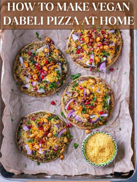 Spicy and tangy Dabeli Pizza topped with dabeli masala, sev, pomegranate seeds, spiced peanuts, and vegan cheese on mini pita bread and text at the top and bottom.