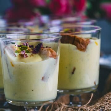 Instant Rabdi Cheesecake topped with saffron strands and pistachios - a creamy Indian fusion dessert made with ricotta cheese and a crunchy rusk base.