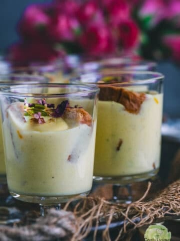 Instant Rabdi Cheesecake topped with saffron strands and pistachios — a creamy Indian fusion dessert made with ricotta cheese and a crunchy rusk base.