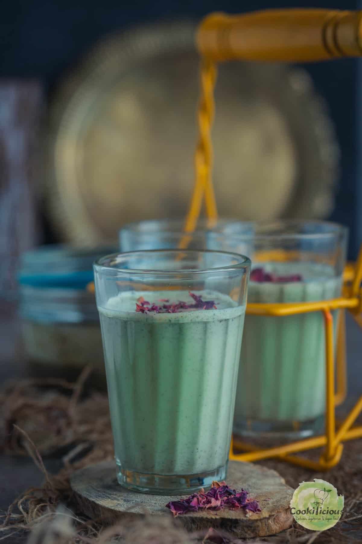 Refreshing Meetha Paan Shots in small glasses with gulkand and green paan leaves, homemade Indian dessert drink.