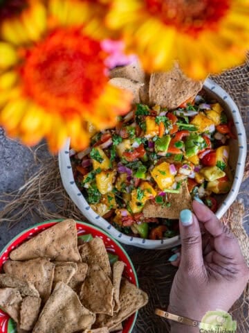 Vegan peach salsa served in a salad bowl with diced peaches, tomatoes, bell peppers, and avocado.