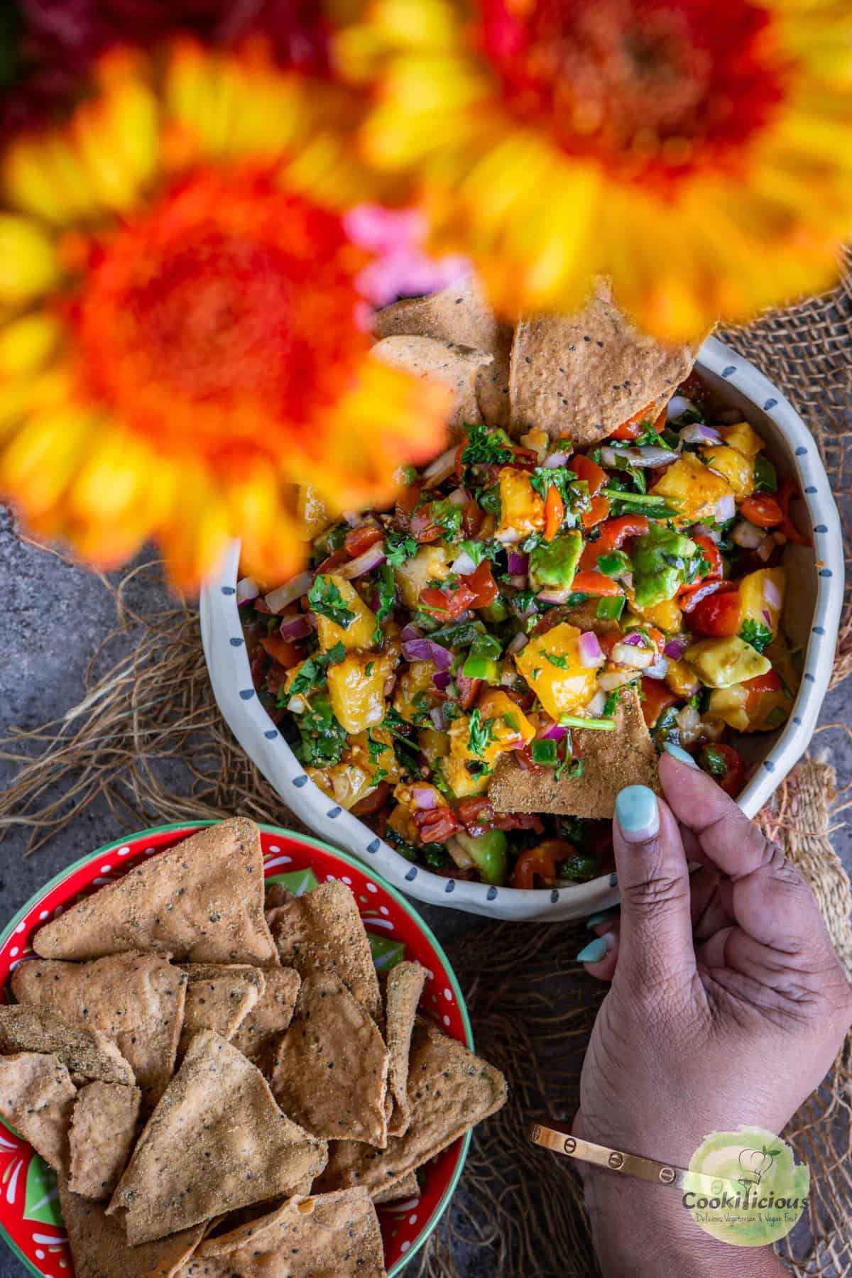 Vegan peach salsa served in a salad bowl with diced peaches, tomatoes, bell peppers, and avocado.