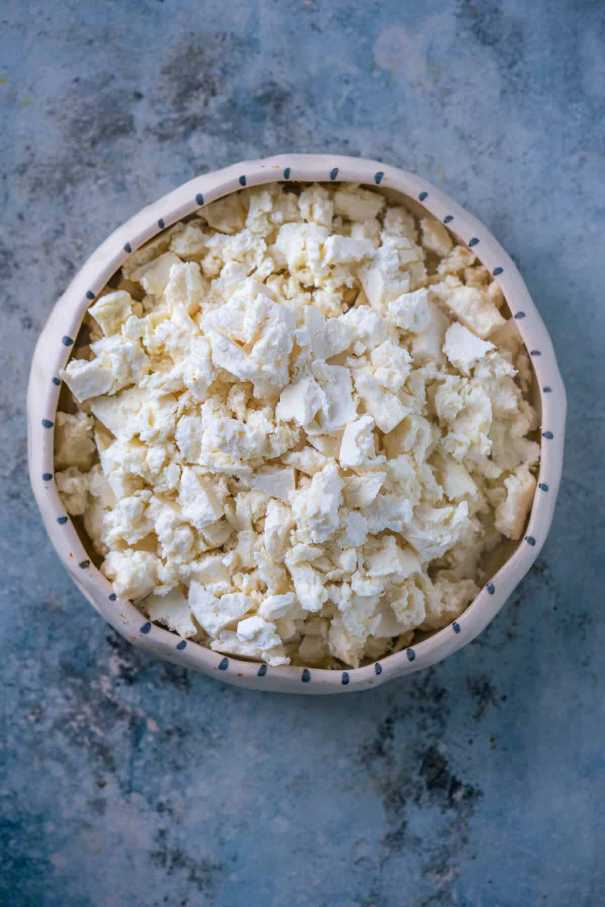 Crumbling fresh paneer into small pieces, ready for cooking Paneer Bhurji.