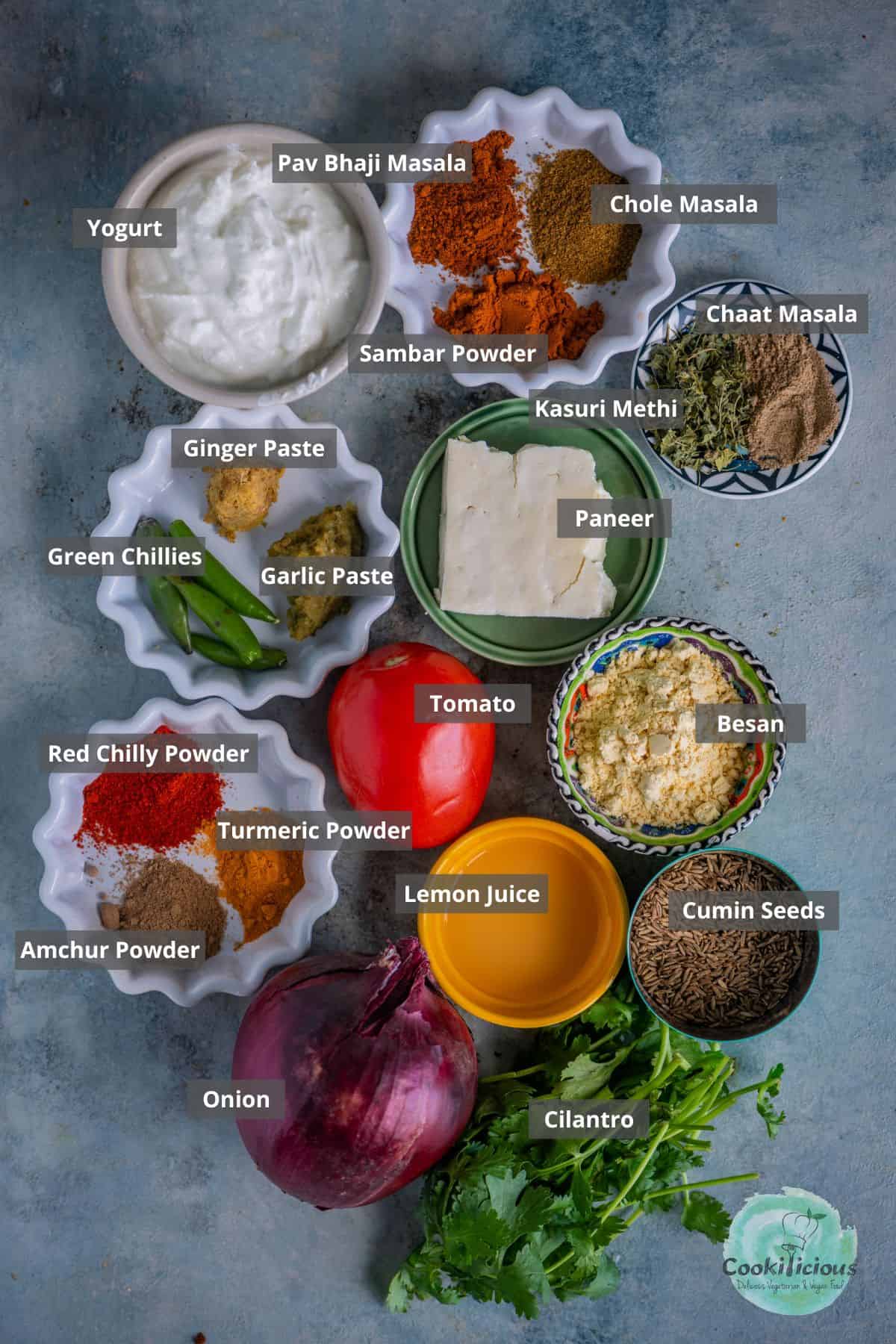 all the ingredients needed to make Amritsari Paneer Bhurji placed on a table with labels on them.