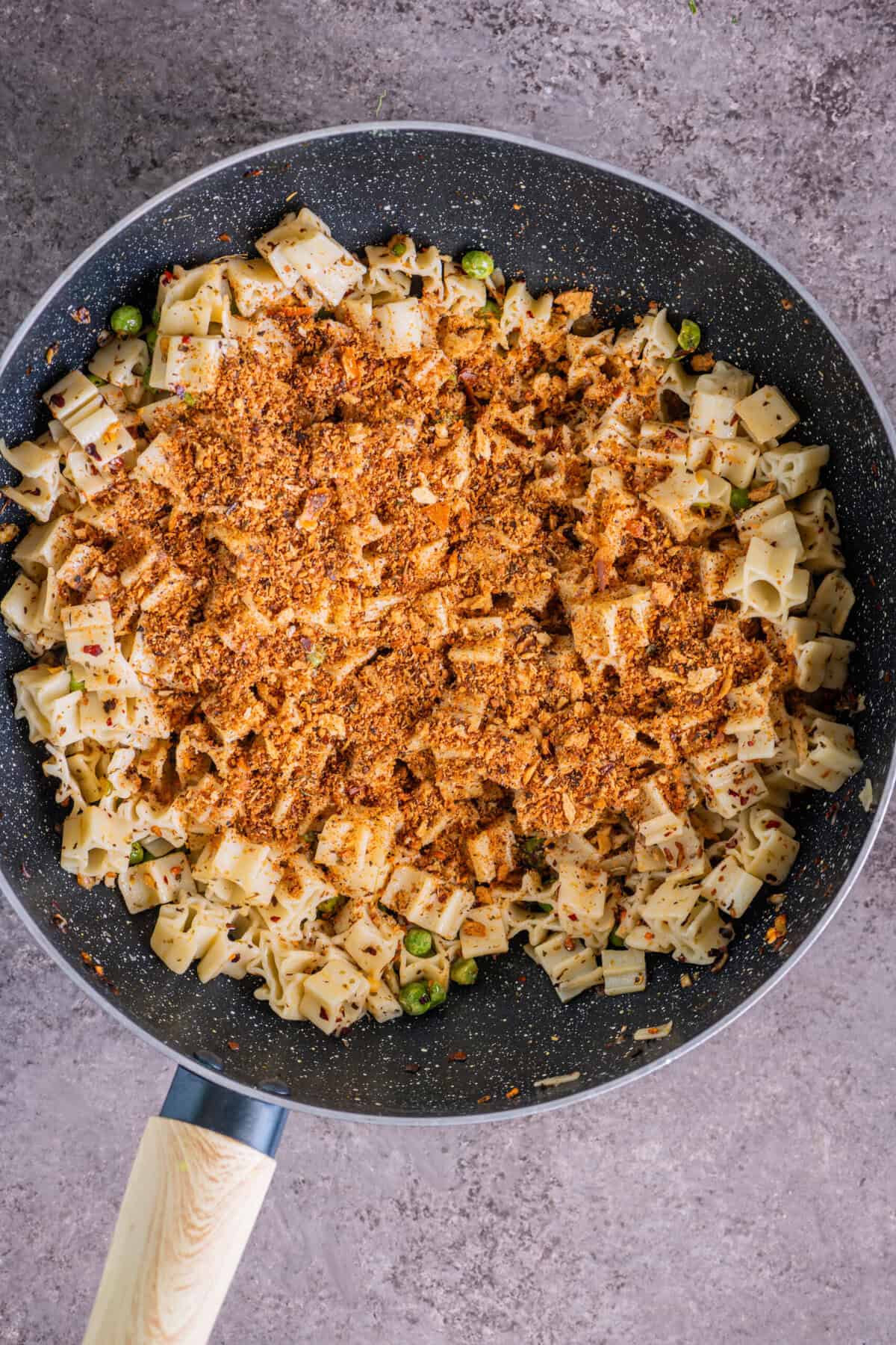 Sprinkling homemade golden breadcrumbs (pangrattato) over hot pasta.