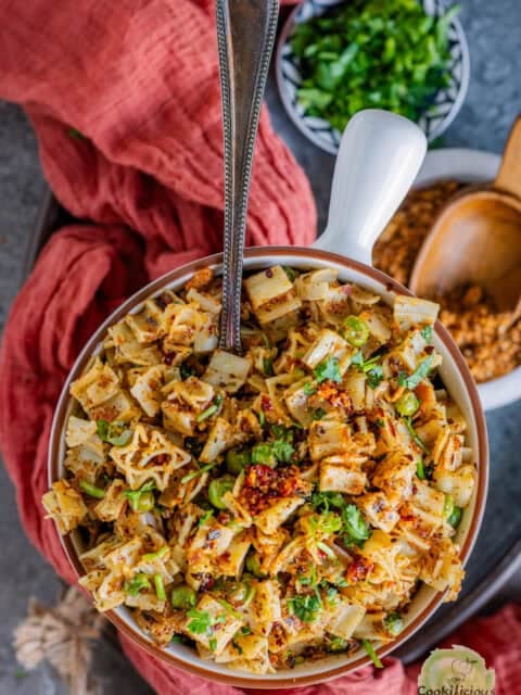 Bowl of pasta with breadcrumbs topped with golden garlic pangrattato and fresh herbs.
