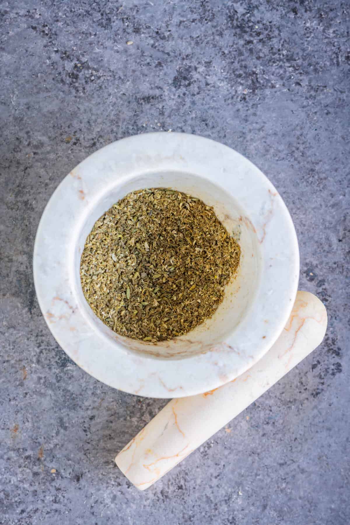 Coarse, fragrant spice mix in a mortar, ready to be added to hot oil to build depth, warmth, and authentic flavor in the rasedar aloo sabzi.