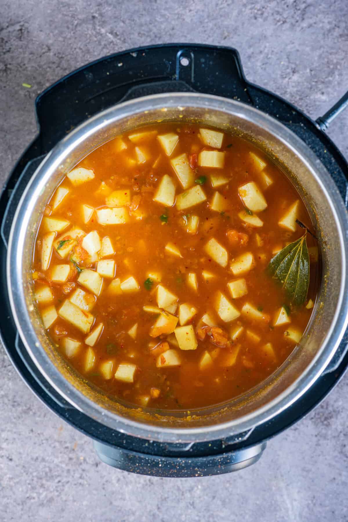 Potatoes and water inside the Instant Pot before sealing the lid to pressure cook the rasedar aloo sabzi.